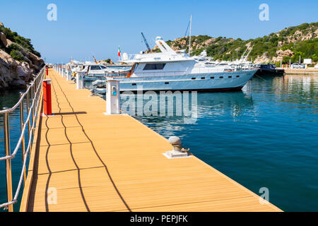 Vue sur quai, Bateau bateaux amarrés à la Marina dell'Orso di Poltu Quatu et entrée du port ; Marina dell'Orso di Poltu Quatu, Sardaigne, Italie. Banque D'Images