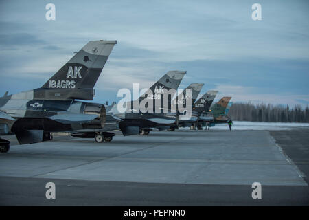 U.S. Air Force F-16 Fighting Falcon avec le 18e escadron agresseur se préparent à décoller d'Eielson Air Force Base, Alaska, peu après le lever du soleil le 24 janvier 2016, en transit vers Kadena Air Base, au Japon, à participer à des exercices de formation. Plus de 150 responsables de la 354e Escadre de chasse gardera les agresseurs dans l'air et de préparer des aviateurs américains, marins et Marines d'opérations d'urgence ainsi que les partenaires de la coalition dans le théâtre du Pacifique. (U.S. Photo de l'Armée de l'air par le sergent. Shawn/nickel libéré) Banque D'Images