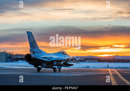 Un U.S. Air Force F-16 Fighting Falcon avec le 18e escadron agresseur se prépare à décoller d'Eielson Air Force Base, Alaska, peu après le lever du soleil le 24 janvier 2016, en transit vers Kadena Air Base, au Japon, à participer à des exercices de formation. Plus de 150 responsables de la 354e Escadre de chasse gardera les agresseurs dans l'air et de préparer des aviateurs américains, marins et Marines d'opérations d'urgence ainsi que les partenaires de la coalition dans le théâtre du Pacifique. (U.S. Photo de l'Armée de l'air par le sergent. Shawn/nickel libéré) Banque D'Images