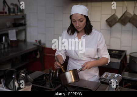 Baker femmes la préparation des aliments dans la cuisine Banque D'Images