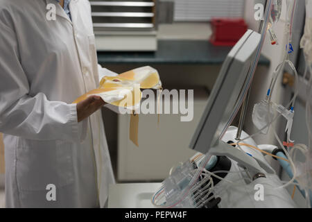 Technicien de laboratoire holding poches de plasma Banque D'Images