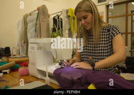 Fashion designer using machine à coudre dans fashion studio Banque D'Images