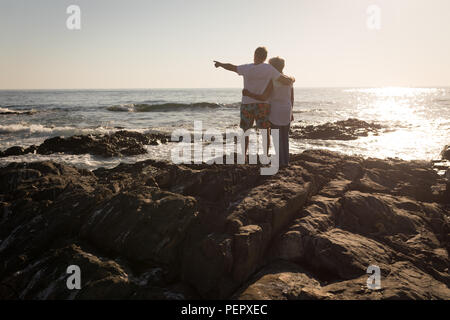 Senior couple standing on rock, près de la mer Banque D'Images