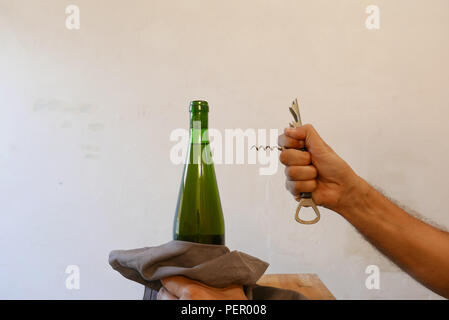 L'homme d'ouvrir une bouteille de vin avec tire-bouchon à la maison Banque D'Images