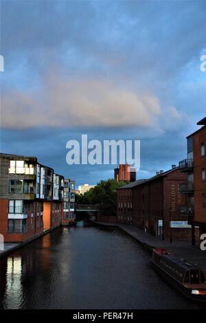 Birmingham England Vue sur canal dans les premières heures du matin avec un beau ciel bleu, les nuages blancs et les bâtiments résidentiels le long du canal Banque D'Images