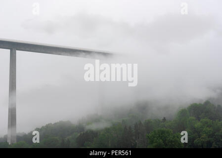 Plus Kochretalbrucke allemand, le viaduc, envahi par le brouillard et les nuages, crossing over green collines boisées, près de Schwabisch Hall, en Allemagne. Banque D'Images