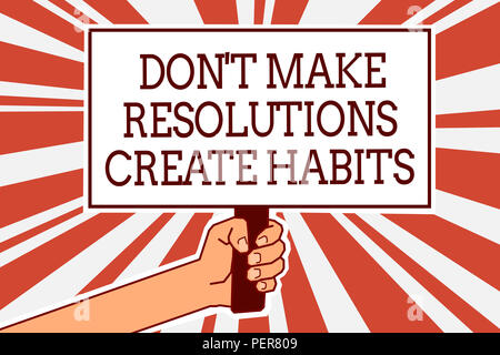 L'écriture note indiquant ne pas prendre des résolutions créer des habitudes. Photo d'affaires mettant en routine pour tous les jours pour atteindre les objectifs de l'affiche de la main qui tient l'Homme Banque D'Images