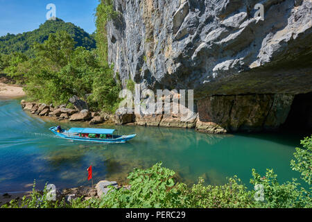 Un bateau de tourisme navigue sur un lac naturel à l'intérieur de grottes de Phong Nha colonne avec des formations rocheuses en arrière-plan. Dans le parc national de Phong Nha, North-Cent Banque D'Images