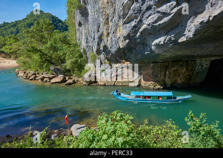 Un bateau de tourisme navigue sur un lac naturel à l'intérieur de grottes de Phong Nha colonne avec des formations rocheuses en arrière-plan. Dans le parc national de Phong Nha, North-Cent Banque D'Images