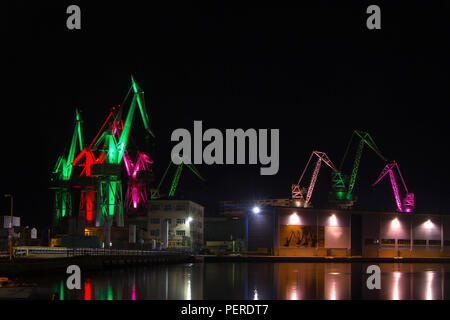 "Chantier naval Uljanik" à Pula, Croatie, dont les grues sont éclairées la nuit par des lumières différentes Banque D'Images