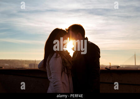 Couple aimant profiter de la tendresse sur une journée ensoleillée sur le toit. Couple sur le toit de la coucher du soleil. Banque D'Images