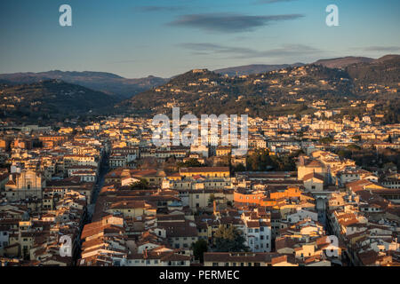 Florence, Italie - 23 mars 2018 : soleil du soir brille sur les toits de la ville de Florence, avec la villa collines recouvertes de Fiesolean derrière. Banque D'Images