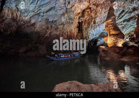 Un bateau de tourisme navigue sur un lac naturel à l'intérieur de grottes de Phong Nha colonne avec des formations rocheuses en arrière-plan. Dans le parc national de Phong Nha, North-Cent Banque D'Images