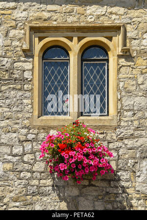 Vue en gros plan d'une fenêtre au plomb, la pierre et panier de fleurs sur l'hôtel de ville de Llantwit Major dans la vallée de Glamorgan. Banque D'Images