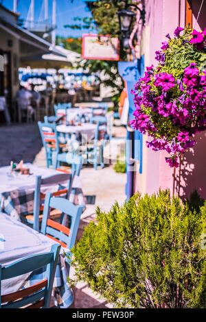 Taverne grecque traditionnelle de couleur vive sur l'étroite rue de la Méditerranée sur la chaude journée d'été Banque D'Images