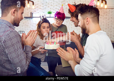 Un groupe de jeunes avec un gâteau d'anniversaire à l'intérieur. Banque D'Images