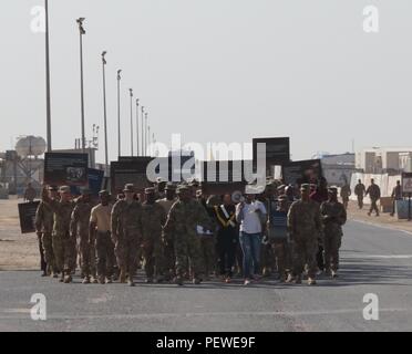 Les soldats de l'Armée américaine affecté à la 2e Brigade de blindés de combat, l'équipe de 1re Division d'infanterie, y compris les soldats du 82e bataillon du génie et de l'armée de soldats de la Garde nationale affecté à la Force Longknife, 40e Brigade d'aviation de combat, en mars célébration de Dr. Martin Luther King Jr. durant la journée Martin Luther King et de la famille, du bien-être social et moral de l'événement de loisirs au Camp Buehring, Koweït, 18 janvier. Les soldats ont défilé comme des faits à propos de Dr. Martin Luther King Jr. ont été lues à haute voix. (Photo de la CPS. Megan O'Malley, 40e Brigade d'aviation de combat Affaires publiques) Banque D'Images