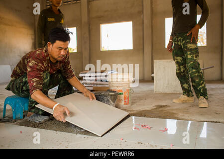 Un soldat thaïlandais avec 52e bataillon du génie, 1er Régiment Kings Guard, des lieux un carreau de sol lors de la construction d'une salle de cours de l'interdiction Raj Bum Roong Middle School, à Lop Buri, Thaïlande, au cours de l'exercice Cobra Gold, le 5 février 2016. Gold Cobra, dans sa 35e version, l'accent sur l'action civique, l'engagement communautaire et des activités médicales à l'appui des besoins et l'intérêt humanitaire des populations civiles de la région. (U.S. Marine Corps Combat Camera photo par le Cpl. Wesley Timm/libérés) Banque D'Images