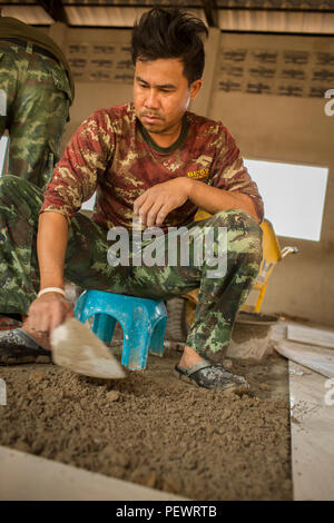 Un soldat thaïlandais avec 52e bataillon du génie, 1er Régiment Kings Guard, des lieux un carreau de sol lors de la construction d'une salle de cours de l'interdiction Raj Bum Roong Middle School, à Lop Buri, Thaïlande, au cours de l'exercice Cobra Gold, le 5 février 2016. Gold Cobra, dans sa 35e version, l'accent sur l'action civique, l'engagement communautaire et des activités médicales à l'appui des besoins et l'intérêt humanitaire des populations civiles de la région. (U.S. Marine Corps Combat Camera photo par le Cpl. Wesley Timm/libérés) Banque D'Images