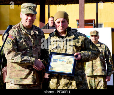 Le lieutenant-colonel Nick Ducich, groupe multinational interarmées, commandant l'Ukraine présente un prix à Mykhaylovych Korenuyk Le Lieutenant-colonel Roman, 1er Bataillon, 24e Brigade mécanisée, 12 février 2016 commandant, au cours de la cérémonie de remise des diplômes de la première rotation de Fearless Guardian II au maintien de la paix et la sécurité internationale Centre près de l'Ukraine, l'viv. La deuxième phase du gardien intrépide sera composée de cinq bataillons de la formation des soldats de l'armée ukrainienne et un bataillon des forces spéciales dans le cadre du groupe multinational interarmées de l'Ukraine. (Photo de Sarah Tate JMTC, Affaires publiques Banque D'Images