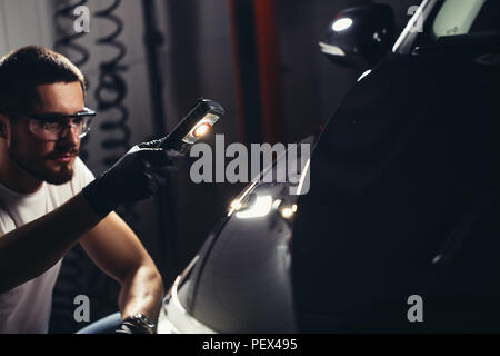 L'homme vérifie le polissage avec une torche Banque D'Images