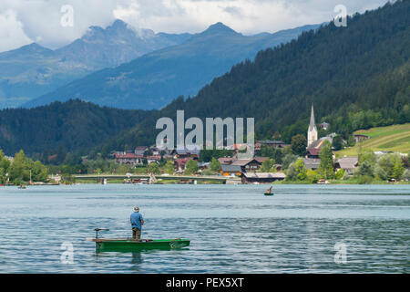 Un pêcheur sur un petit bateau dans le lac Weissensee, Autriche Banque D'Images