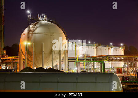 L'huile et les réservoirs à gaz liquide dans une usine chimique dans la nuit. Banque D'Images