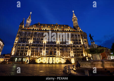 L'hôtel de ville d'Aachen, Allemagne avec ciel bleu nuit et l'éclairage. La fontaine de droite est l'ancien et célèbre Karlsbrunnen. Banque D'Images