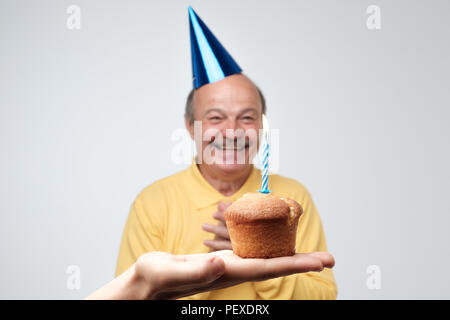 Happy senior man in hat est birtyday happpy à recevoir petit gâteau avec une bougie. Je suis tellement heureuse que vous vous souvenez de mon parti concept Banque D'Images