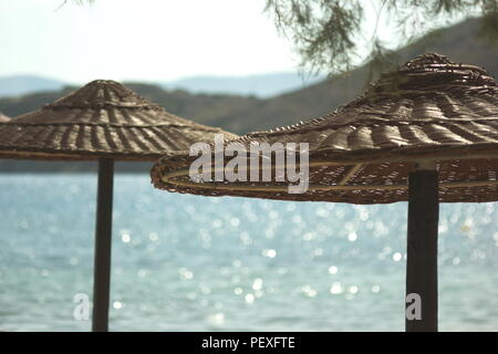 Grèce l'île de Ios. Deux parasols sur Yailos - port (port) beach Banque D'Images