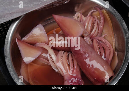 Nettoyer les calmars dans un bassin dans le marché Banque D'Images