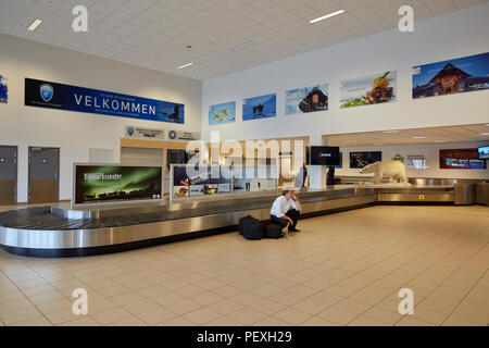 Homme fatigué à un carrousel à bagages vide à l'aéroport de Longyearbyen Longyearbyen Svalbard Lufthavn Banque D'Images