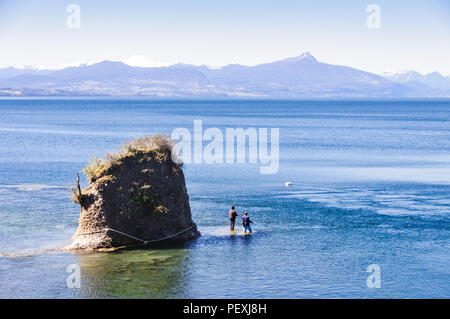 Santiago, Chili - 27 septembre 2009 : deux hommes se tenir la pêche dans le lac Rupanco Lago, avec les montagnes volcaniques de Casablanca, Antillanca et Cerro Sarnos Banque D'Images
