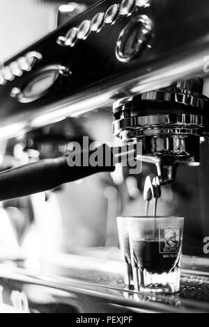 Faire du café espresso BW noir et blanc close up detail avec machine à café moderne et verres Banque D'Images