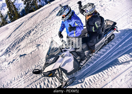 L'homme et la femme équitation motoneige, Callaghan Valley, Whistler, British Columbia, Canada Banque D'Images