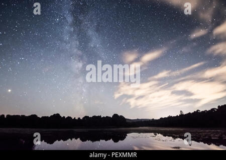 La Voie Lactée vu plus de Burton Mill Pond, minces nuages filandreux, le Parc National des South Downs, Petworth, Sussex, UK. En août. La nuit. Banque D'Images