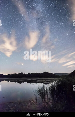 La Voie Lactée vu plus de Burton Mill Pond, minces nuages filandreux, le Parc National des South Downs, Petworth, Sussex, UK. En août. La nuit. Banque D'Images