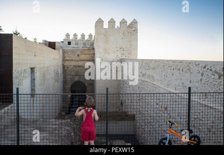 Garçon enfant observant le shoehorse Alpendiz de arch, citadelle mauresque Badajoz, Estrémadure, Espagne Banque D'Images