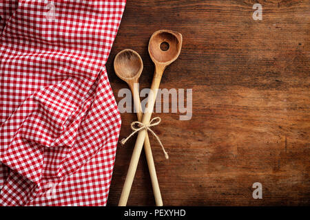 Des ustensiles de cuisine en bois et de pique-nique à carreaux rouge et blanc, nappe sur une table en bois, vue du dessus, copy space Banque D'Images