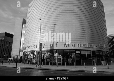 Manchester, Royaume-Uni - 25 juillet 2018 : Un cycliste passe par le grand bâtiment en forme de tambour, de l'Université de Manchester, University Place Banque D'Images