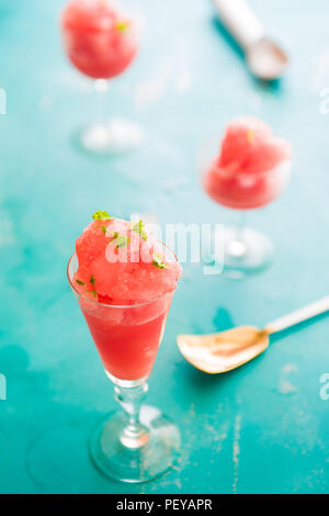 Warermelon granita sur un petit verre sur un fond bleu avec l'accent technique sélective Banque D'Images