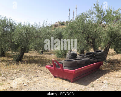 Les constructeurs rouge saute avec pneus en caoutchouc sur le terrain vague près de Alora Andalousie Banque D'Images