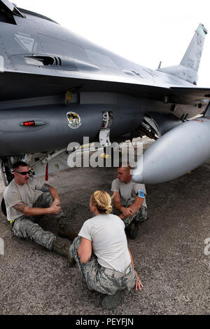 U.S. Air Force Tech. Le Sgt. Codylynn Knab, infirmier affecté à la 112e Escadron de chasse de l'expéditionnaire, le contrôle des deux chefs d'équipage de son unité, Senior Airman Joshua Miller et le sergent. Centres de Brant, comme ils l'abri sous l'ombre d'un F-16 Fighting Falcon sur la ligne de vol à Andersen Air Force Base, Guam le 15 février 2016, au cours de l'effort à faire face au nord en 2016. Exercices de formation tels que le CN16, les États-Unis, le Japon et l'Australie, les forces de l'air développer les capacités de combat, l'amélioration de la supériorité aérienne, la guerre électronique, de l'interdiction aérienne, le transport aérien tactique et aerial refueling. (U.S. Air National Guard phot Banque D'Images