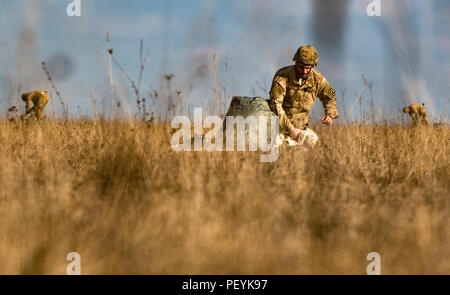 Un parachutiste du 4e bataillon du 319e Régiment d'artillerie (Airborne), 173e Brigade aéroportée, packs son T-11 dans le parachute Aviator's kit sac après exécution réussie de la 5ème point de performances à la zone d'entraînement Grafenwoehr - zone de liste déroulante de soute, en Allemagne, le 18 février 2016. Plus de 200 parachutistes menée à partir de deux sauts de compétence dans l'UH-60L Black Hawk hélicoptères à 3e Bataillon 227e Régiment d'aviation, Groupe de travail de Lance, le 18 février 2016, à Bunker drop-zone Grafenwoehr, Allemagne. (U.S. Photo de l'armée par le Sgt. Thomas Mort) Banque D'Images