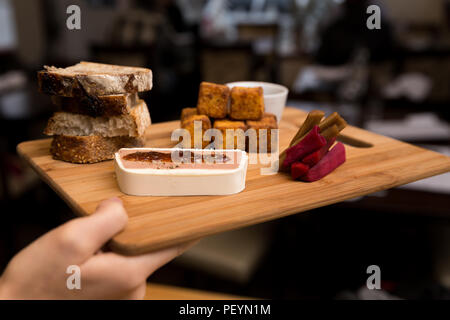 Un plateau d'apéritif de style européen composé de mousse de foie, beignets, pain, polenta et carottes confites. Banque D'Images