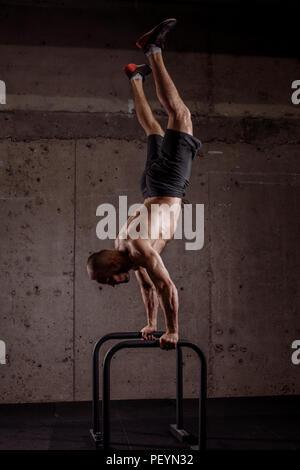 Bien construit gymnast sur barres parallèles. photo pleine longueur. la coordination et concept de bien-être Banque D'Images