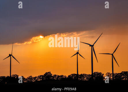 Sieversdorf, Allemagne. Août 17, 2018. Le soleil se couche derrière les nuages sombres sur un paysage avec des éoliennes. Crédit : Patrick Pleul/dpa-Zentralbild/dpa/Alamy Live News Banque D'Images