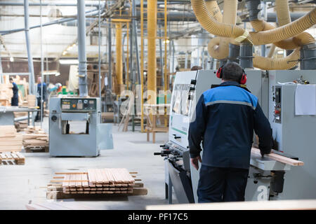 Le Bélarus, la ville de Gomel, le 26 avril 2018. Usine de meubles. Boutique pour la transformation du bois et la fabrication de meubles. Travaillant dans le casque derrière t Banque D'Images