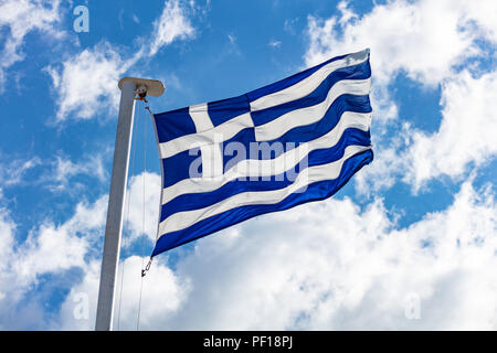 Drapeau grec sur mât agitant sur fond de ciel bleu Banque D'Images