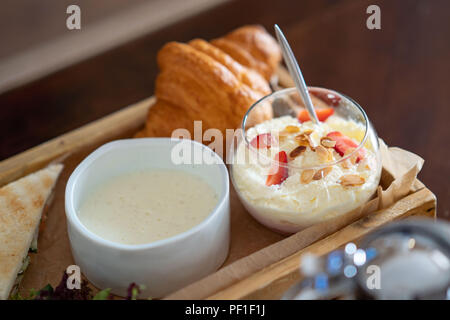 Table de petit-déjeuner avec du porridge d'avoine, de croissants, de fruits frais et de muffins shot Banque D'Images